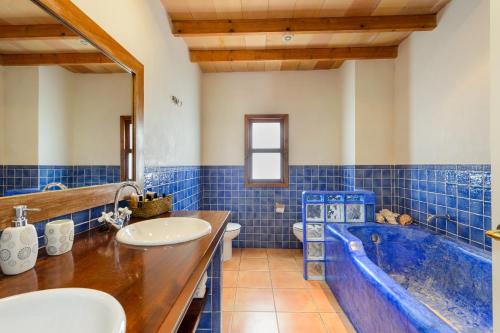 a blue tiled bathroom with a tub and a sink at La Vila Ibiza in Sant Josep de sa Talaia