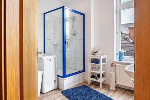 a bathroom with a shower with a blue frame at Ferienwohnung Ebbe am Weserstrand in Sandstedt