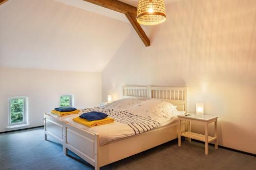a bedroom with a bed with a nightstand and a table at Ferienwohnung Ebbe am Weserstrand in Sandstedt