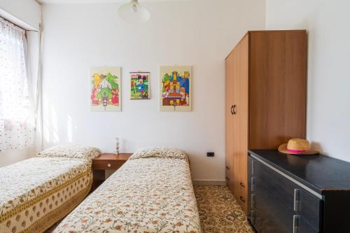 a bedroom with two beds and a dresser at Su entu a mari Museddu in Cardedu