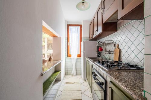 a kitchen with a sink and a stove top oven at Su entu a mari Museddu in Cardedu