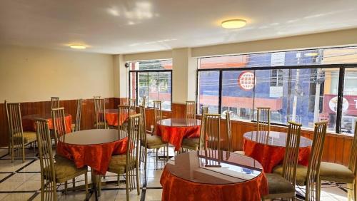 a restaurant with tables and chairs with red table cloth at Hotel Palmeras Tacna in Tacna