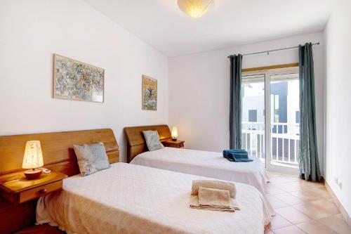 a bedroom with two beds and a balcony at Apartamento Maré Cheia Sl40 in Santa Luzia