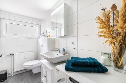 a white bathroom with a sink and a toilet at Ferienwohnung Carolin Witt in Großsolt