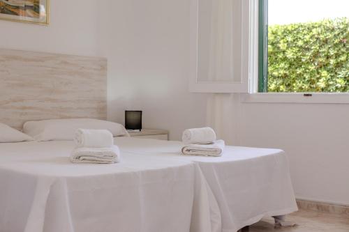 a white room with a table with towels on it at Biniforcat 21 in Cala en Forcat