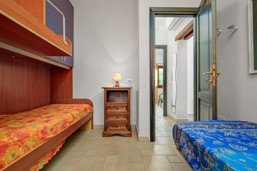 a bedroom with two beds and a dresser in it at Trilo La Rosa in Monte Petrosu