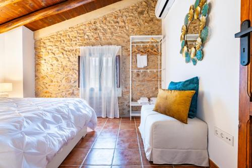 a bedroom with a bed and a chair in a room at Mas de Morera in Vall dʼAlba