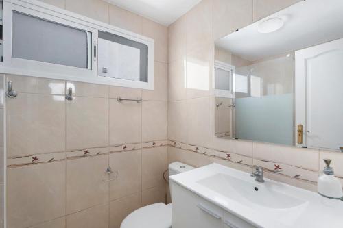 a bathroom with a toilet and a sink and a mirror at Nido Andrea in San Isidro