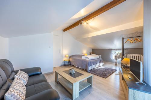 a living room with a couch and a bed at Gite Augustine Aux Charmes D'antan in Sevremont