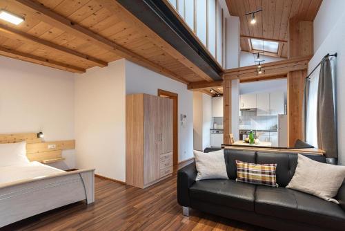 a living room with a couch and a kitchen at Schrotthof in Feldthurns