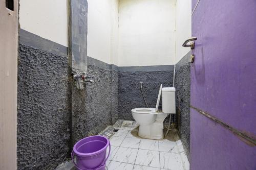 a bathroom with a toilet and a purple door at Simple Hotel Bogor RedPartner in Bogor