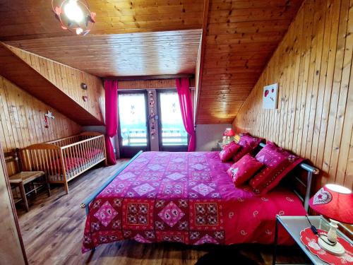 a bedroom with a pink bed in a wooden room at Le Gite Fleuri in Hazelbourg