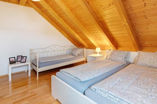 two beds in a room with a wooden ceiling at Sonnige Ferienwohnung mit Balkon in Küssaberg