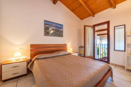 a bedroom with a bed and two lamps on tables at Villa Birgit in Monte Nai
