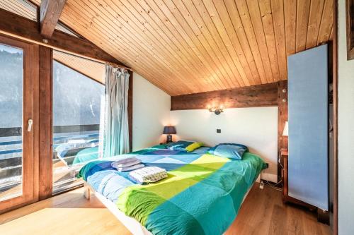 a bedroom with a bed and a large window at Chalet Châtel - calme et spacieux in Châtel