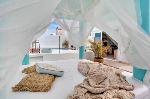 a white bed with towels on it with a window at Orange Light with private pool in Corralejo