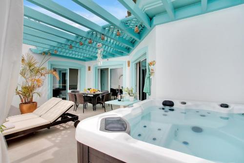 a large bathroom with a tub and a table at Orange Light with private pool in Corralejo