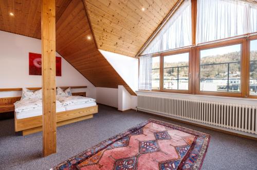 a attic room with two beds and a large window at Gästehaus Noller in Bodman-Ludwigshafen