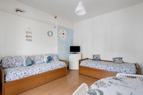 a bedroom with two beds and a tv on the wall at Porta Delle 5 Terre in Levanto