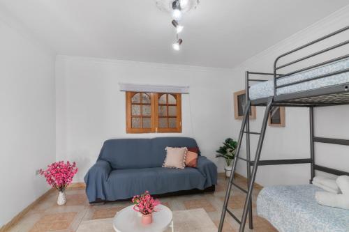 a living room with a blue couch and a bunk bed at Casa Zoiben in San Nicolás