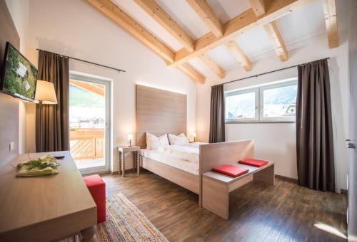 a hotel room with a bed and a table at Alpenblick Nr 8 in Campo Tures