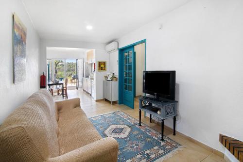 a living room with a couch and a flat screen tv at Casa Tibagota in São Brás de Alportel
