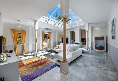 a living room with a white couch and a table at Villa Domus Vesta in Marbella