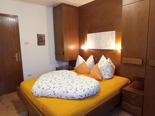 a bedroom with a yellow bed with white sheets and pillows at Apartement Annabelle in Lana