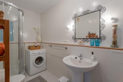 a bathroom with a sink and a washing machine at Mi Casa in Caleta De Velez