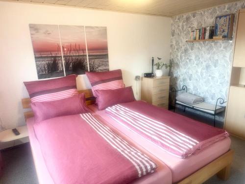 a bedroom with a large bed with pink sheets at Ferienwohnung Beyer Friedrichroda in Friedrichroda