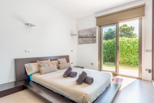 a white bedroom with a large bed and a window at Villa Zoe in Palma de Mallorca