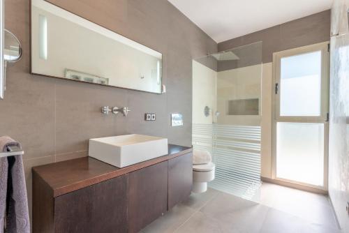 a bathroom with a sink and a toilet and a mirror at Villa Zoe in Palma de Mallorca
