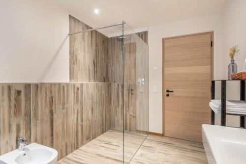 a bathroom with a shower with a glass door at Aumia Apartment Rubin in Völs am Schlern