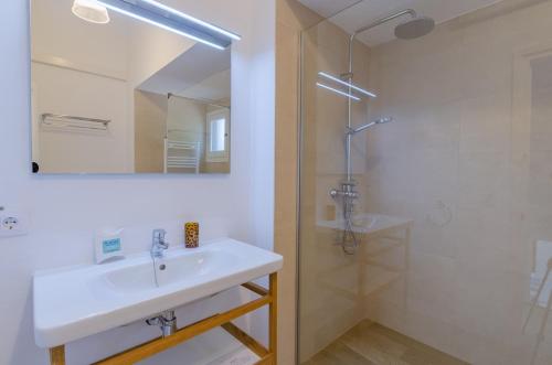 a white bathroom with a sink and a shower at Villa Diani in Binibeca