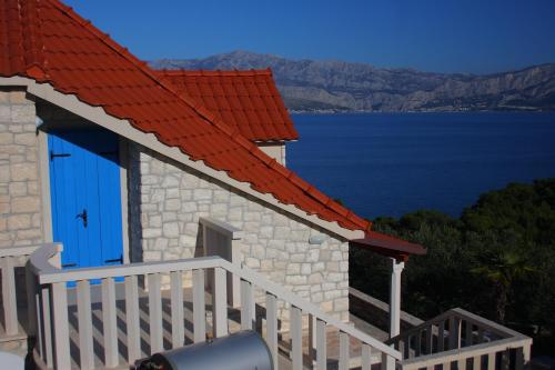 a small house with a red roof and a staircase at Holiday Home Olea - Sun, Sea, Sport & Comfort in Splitska