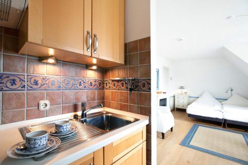 a kitchen with a sink and a room with a couch at Ferienwohnung Haus Lazy Dolphin in Rantum
