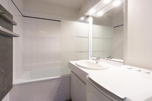 a white bathroom with a sink and a tub at Appartement Albiez in Albiez-Montrond