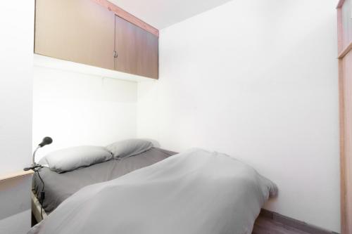 a bedroom with a white bed and a cabinet at Appartement Albiez in Albiez-Montrond