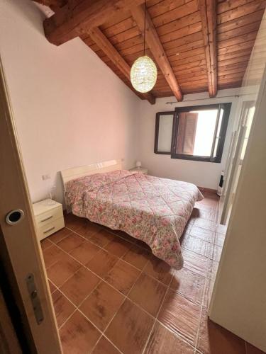 a bedroom with a bed and a wooden ceiling at Orizzonti 32 in Golfo Aranci