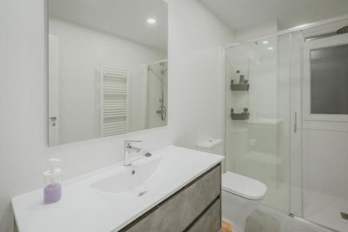 a white bathroom with a sink and a toilet at Mónaco in Valladolid