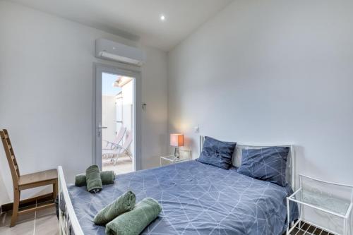 a bedroom with a blue bed and a chair at Le Boumian in Saintes-Maries-de-la-Mer