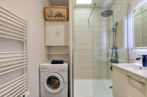 a bathroom with a washing machine and a sink at Le Boumian in Saintes-Maries-de-la-Mer