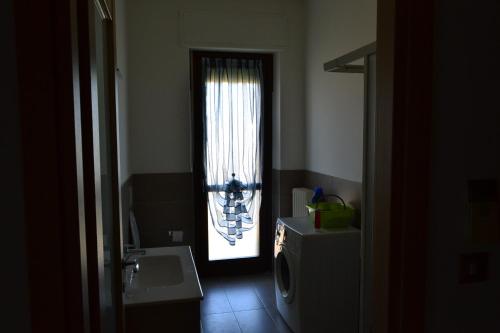 a bathroom with a door leading to a window at Alloggio per 4 persone con due camere da letto e cucina in Carrù
