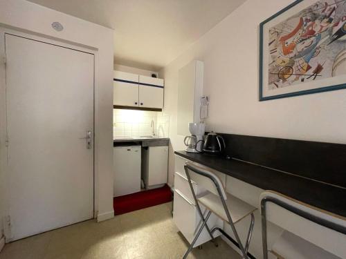 a small kitchen with a desk and a refrigerator at Hyper centre, rue piétonne, calme in Dijon