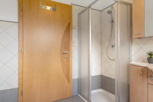 a shower with a wooden door in a bathroom at Ferienhaus Berger in Sarntal
