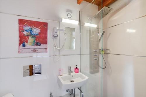 a white bathroom with a sink and a shower at Villa Estanco 14 in Vega de San Mateo