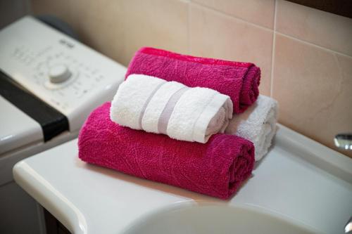 a pile of towels sitting on top of a toilet at Casa Vacanza Ghisu in SantʼAnna Arresi
