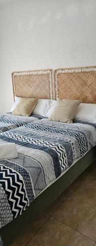 a bed with a quilt and pillows on it at Ainara Luxury in Lloret de Mar