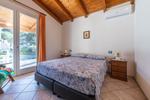 a bedroom with a bed and a large window at Casa Vacanza Ghisu in SantʼAnna Arresi