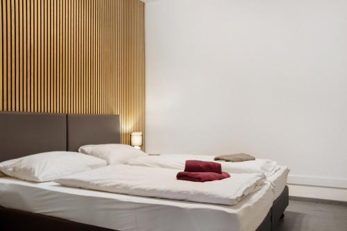 a bed with white sheets and a red towel on it at Maiglöckchen in Unterwittighausen